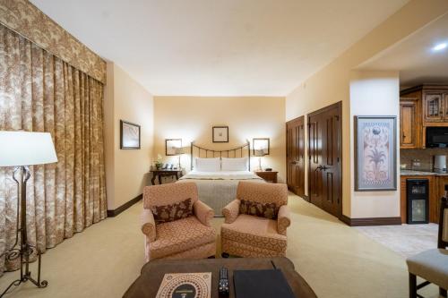 休斯顿休斯敦大公爵酒店的酒店客房,配有一张床和两把椅子