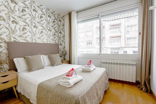 巴塞罗那阿尔卡姆金色公寓的一间卧室配有两张带毛巾的床