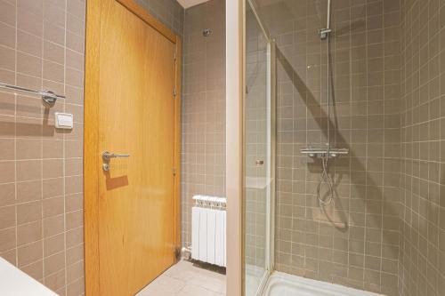 巴塞罗那阿尔卡姆金色公寓的浴室里设有玻璃门淋浴