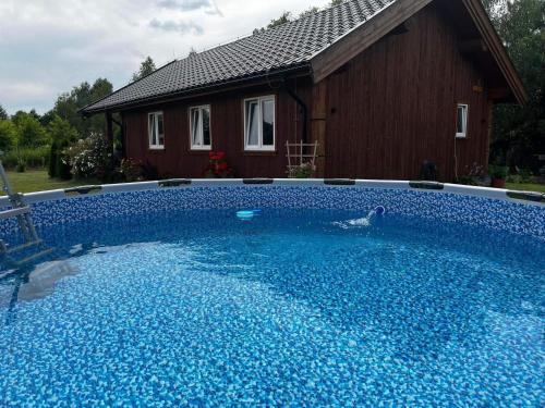 拉达瓦Brzozowa Aleja的一座大蓝色游泳池,位于房子前