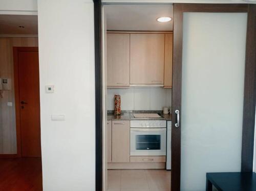 韦斯卡Acogedor apartamento con piscina y garaje的厨房配有白色橱柜和炉灶烤箱。