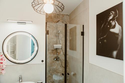 锡比乌ARINI WHITE HOUSE的带淋浴和镜子的浴室