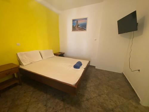洛加拉斯Yellow Beach House的一间小卧室,配有一张床和一台平面电视