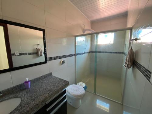 帕罗卡03 - Casa praia pinheira perto da guarda的一间带玻璃淋浴和水槽的浴室