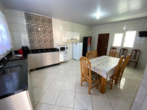 帕罗卡03 - Casa praia pinheira perto da guarda的带桌椅的厨房以及带桌子和桌子的厨房。