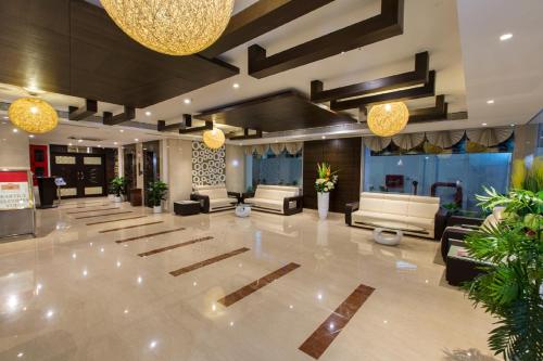 蒂鲁帕蒂排总督酒店的大型大堂配有沙发、桌子和灯