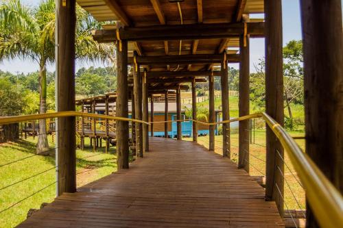 波萨达斯Hotel Maitei Posadas的通往度假村游泳池的木制走道