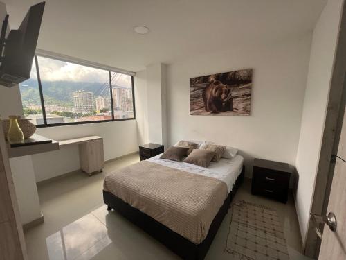 伊瓦格Hermoso Apartamento ibague 401 F1的一间卧室设有一张床和一个大窗户