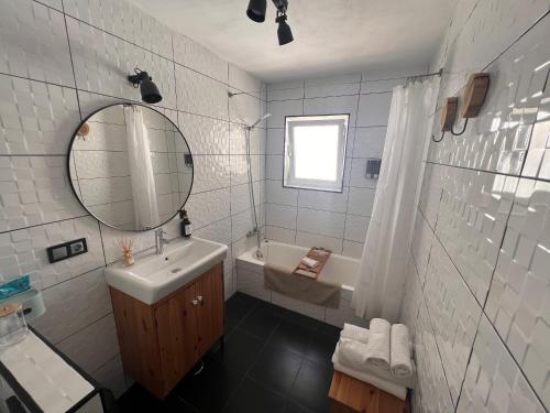 米哈斯Casa Olalla的浴室配有盥洗盆、镜子和浴缸