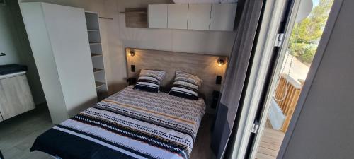 圣拉斐尔Mobil Home Neuf Vue mer的一间小卧室,配有一张带木制床头板的床