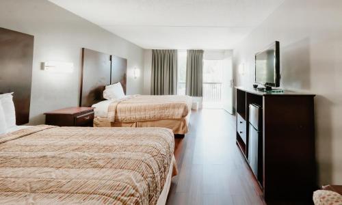 桑兹顿Sandston Inn的酒店客房设有两张床和一台平面电视。