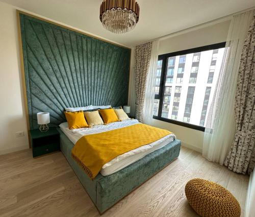 贝尔格莱德SuprStay - Belgrade Waterfront Luxury Apartment的一间卧室配有一张带黄色枕头的床和一扇窗户