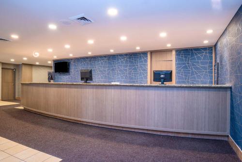 隆格伊蒙特利尔桑德曼酒店 - 隆格伊的一个带前台柜台和蓝色瓷砖的办公大厅