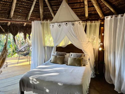 阿布拉奥Jungle Lodge的一间卧室配有一张带天蓬的白色床
