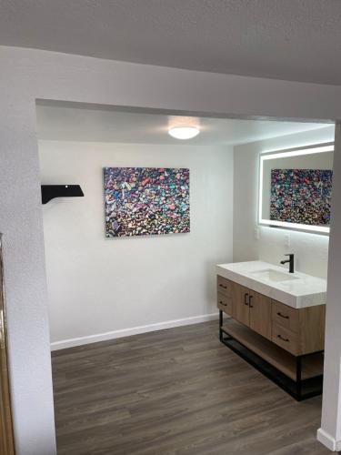 波尔森Americas Best Value Inn Polson的一间带水槽的浴室和墙上的两幅画