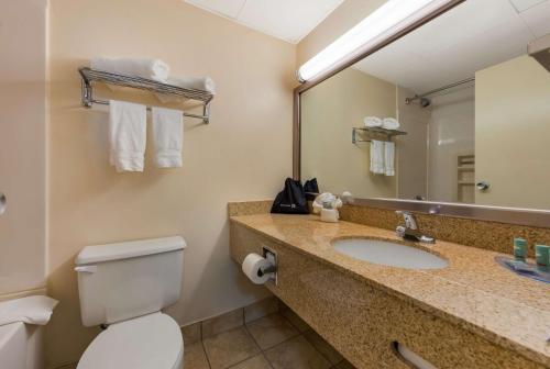西黑文新天堂西天堂贝斯特韦斯特行政酒店的一间带水槽、卫生间和镜子的浴室