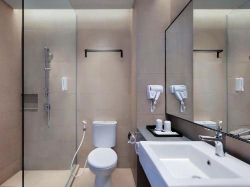 泗水ibis Surabaya Tidar的浴室配有卫生间、盥洗盆和淋浴。