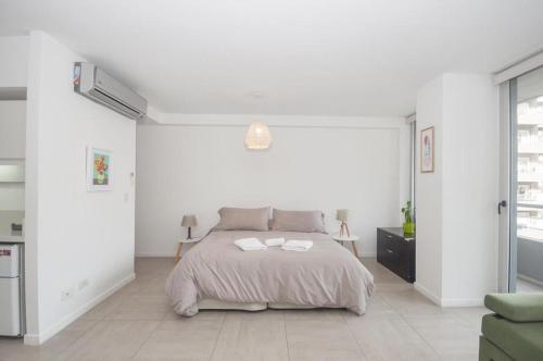 布宜诺斯艾利斯Libertador Complete Suite的白色卧室配有带2条毛巾的床