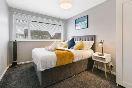 谢菲尔德Superb 3 bed house, with homely comforts and secure parking on gated premise的一间卧室设有一张大床和一个窗户。