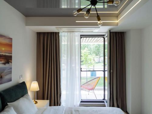 奥林普Bond Apartment - Astria Olimp的一间卧室设有一张床和一个带庭院的窗户。