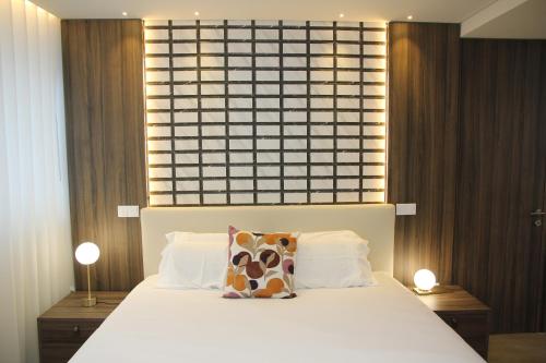 波尔图BrandApartments的一间卧室配有一张带两盏灯的大型白色床。
