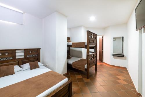 库库塔HOTEL TASAJERO VIP的一间卧室配有两张床和一张双层床。