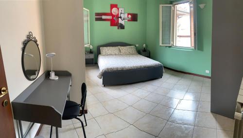 斯特雷萨Garibaldi 26的一间卧室配有一张床、一张书桌和一面镜子