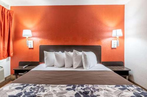 佩科斯Rodeo Inn的橙色墙壁的酒店客房内的一张床位