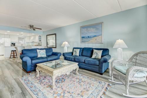 费南迪纳比奇Striking Oceanview Condo的客厅配有蓝色的沙发和咖啡桌