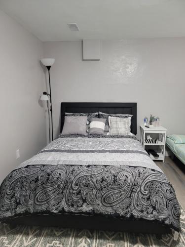 多伦多Falstaff Home的一间卧室配有一张带黑白色床罩的床。