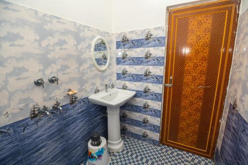 卡齐兰加Jungle Eco Mansion的浴室设有水槽和蓝色瓷砖淋浴。