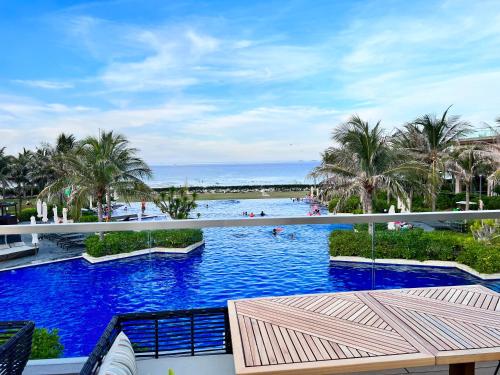 芽庄Cam Ranh Villa的一座棕榈树和海洋的大型游泳池