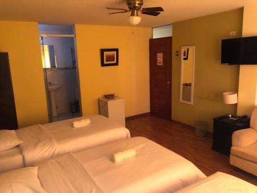 特鲁希略Hotel Las Condes的酒店客房,设有两张床和一张沙发