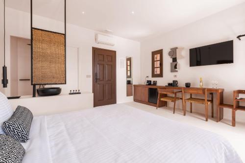 纳克索乔拉Akre Hotel的白色卧室配有床和书桌