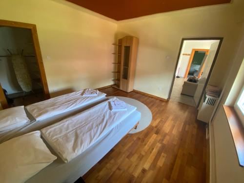 KőröshegyInner House的卧室配有白色的床,铺有木地板