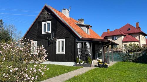 皮什Domek Mazury Pisz的黑色房子,有橙色屋顶