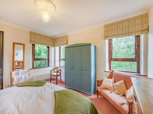 佩特利布里奇Fog Close Cottage的一间卧室配有一张床、一张沙发和窗户。