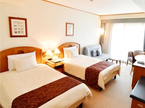 舞鹤市Hotel BELLMARE ホテルベルマーレ的酒店客房,配有两张床和椅子