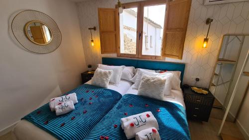 蒙坦切斯El Edén Casas Rurales con Piscina y Jacuzzi的一间卧室配有两张带枕头和镜子的床