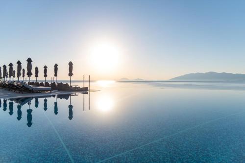 Ágios Fokás米开朗基罗度假及Spa酒店的棕榈树和太阳的海水游泳池