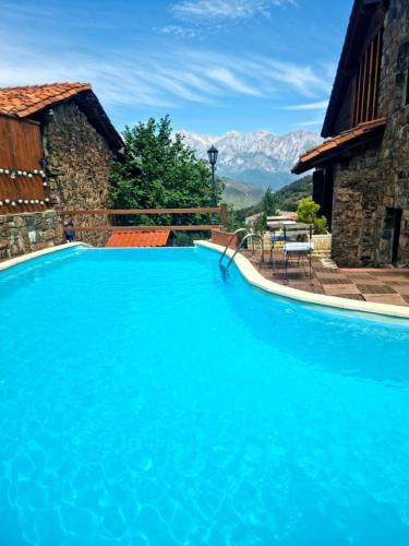 TudesLa Casa de las Chimeneas的一个大型蓝色游泳池,后面是群山