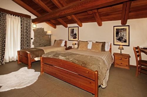 萨奥兹-杜尔克斯Chalet Faure的一间卧室配有两张床和一张桌子及椅子