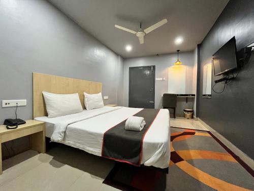 古瓦哈提RJB Grand的一间带大床和电视的卧室