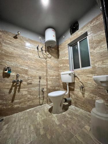 古瓦哈提RJB Grand的浴室配有卫生间、淋浴和盥洗盆。