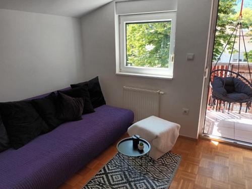 科巴里德City Nest Apartment的客厅配有紫色沙发和窗户