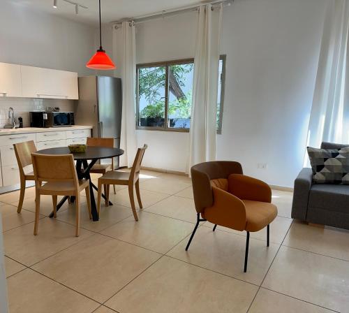 特拉维夫Roza Apartment的厨房以及带桌椅的起居室。