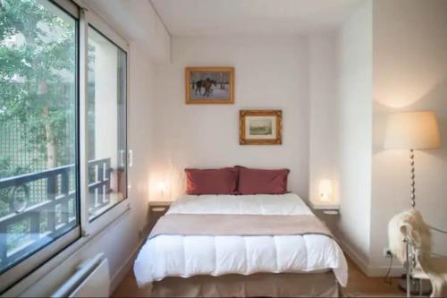 塞纳河畔讷伊Logement entier : appartement • Chez Cecile的一间卧室设有一张床和一个大窗户