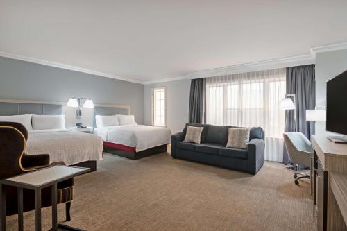 斯坦福德斯坦福希尔顿恒庭旅馆&套房酒店的酒店客房,设有两张床和一张沙发