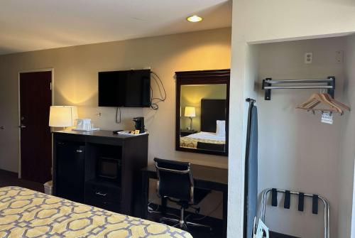 法明顿法明顿品质酒店的一间卧室配有一张床、一张书桌和一面镜子