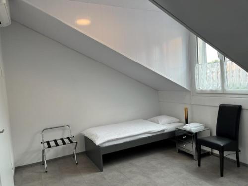 KerzersHotel Hippel Krone的白色的客房配有一张床和椅子